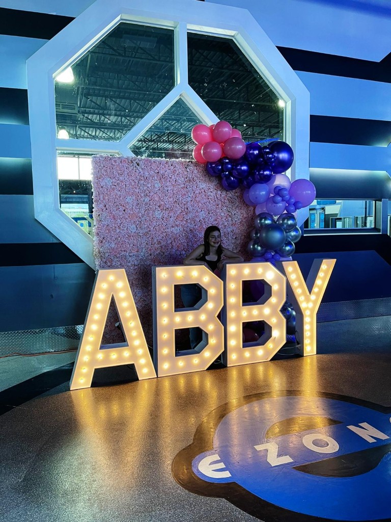Rent Bowmanville marquee letters framed by a balloon arch and a Bowmanville flower wall backing it