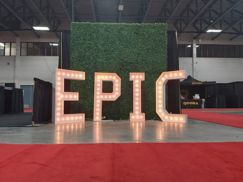 Rent marquee letters with a red carpet and green boxwood wall
